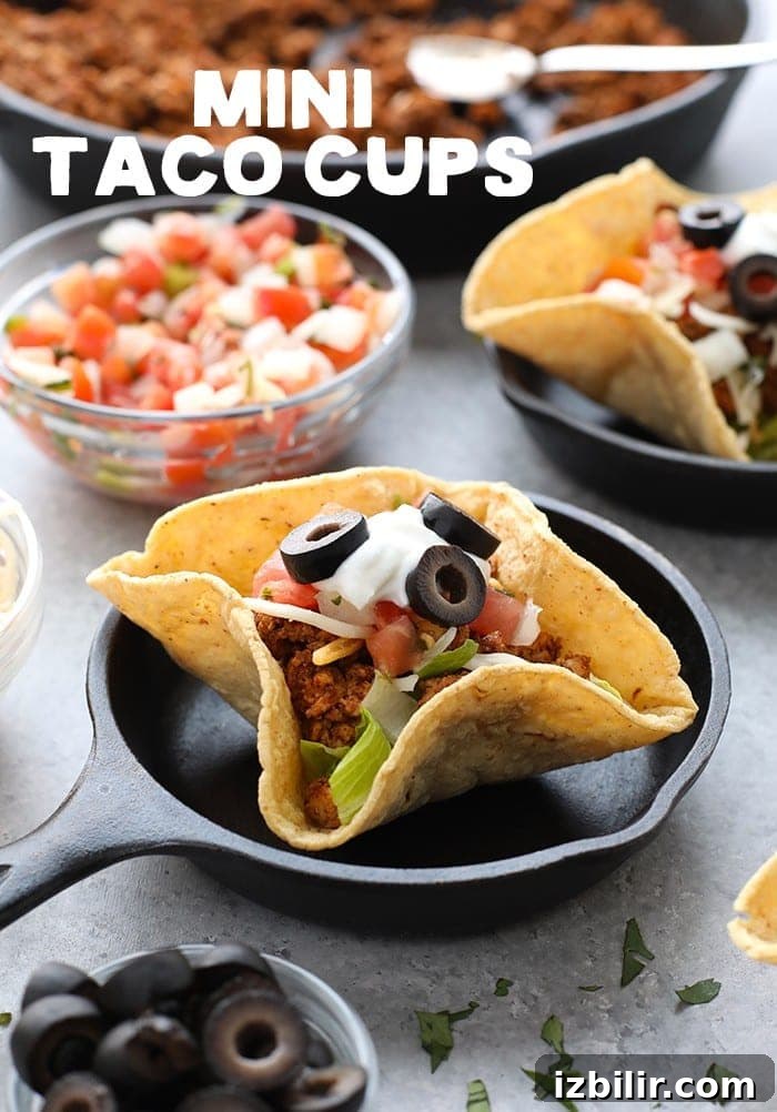 Taco night just got a whole lot cuter! Get the whole family involved and make these adorable mini taco cups made with homemade hard shell taco boats. Mini taco cups on a plate.