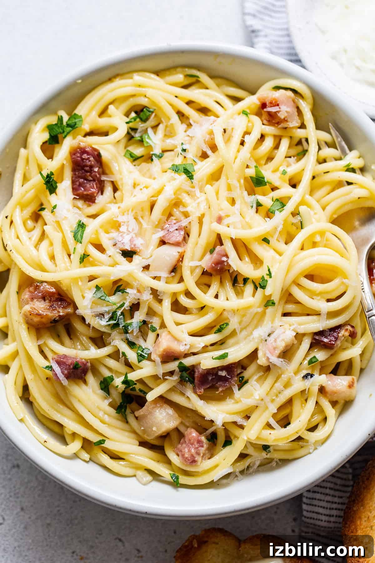 Classic Creamy Carbonara Recipe 5 Pasta with bacon and parmesan in a white bowl.