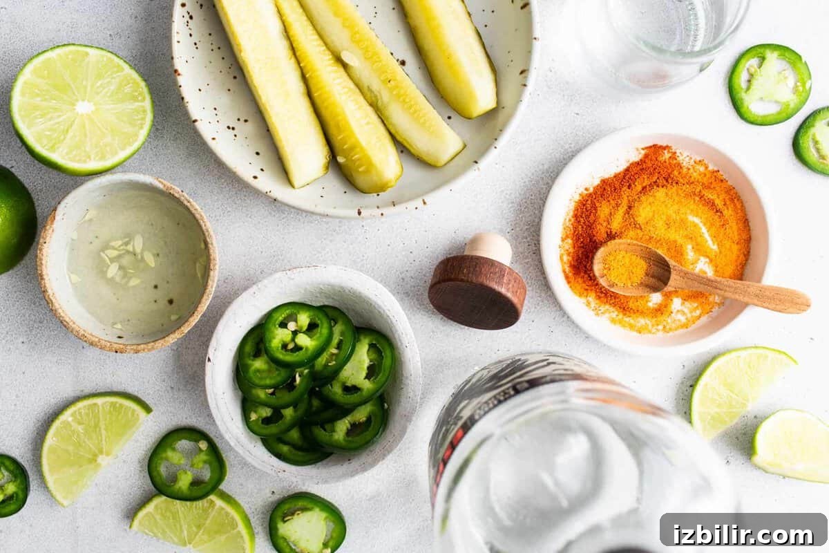 Spicy pickle margarita ingredients including jalapeños, limes, pickle juice, and tequila.
