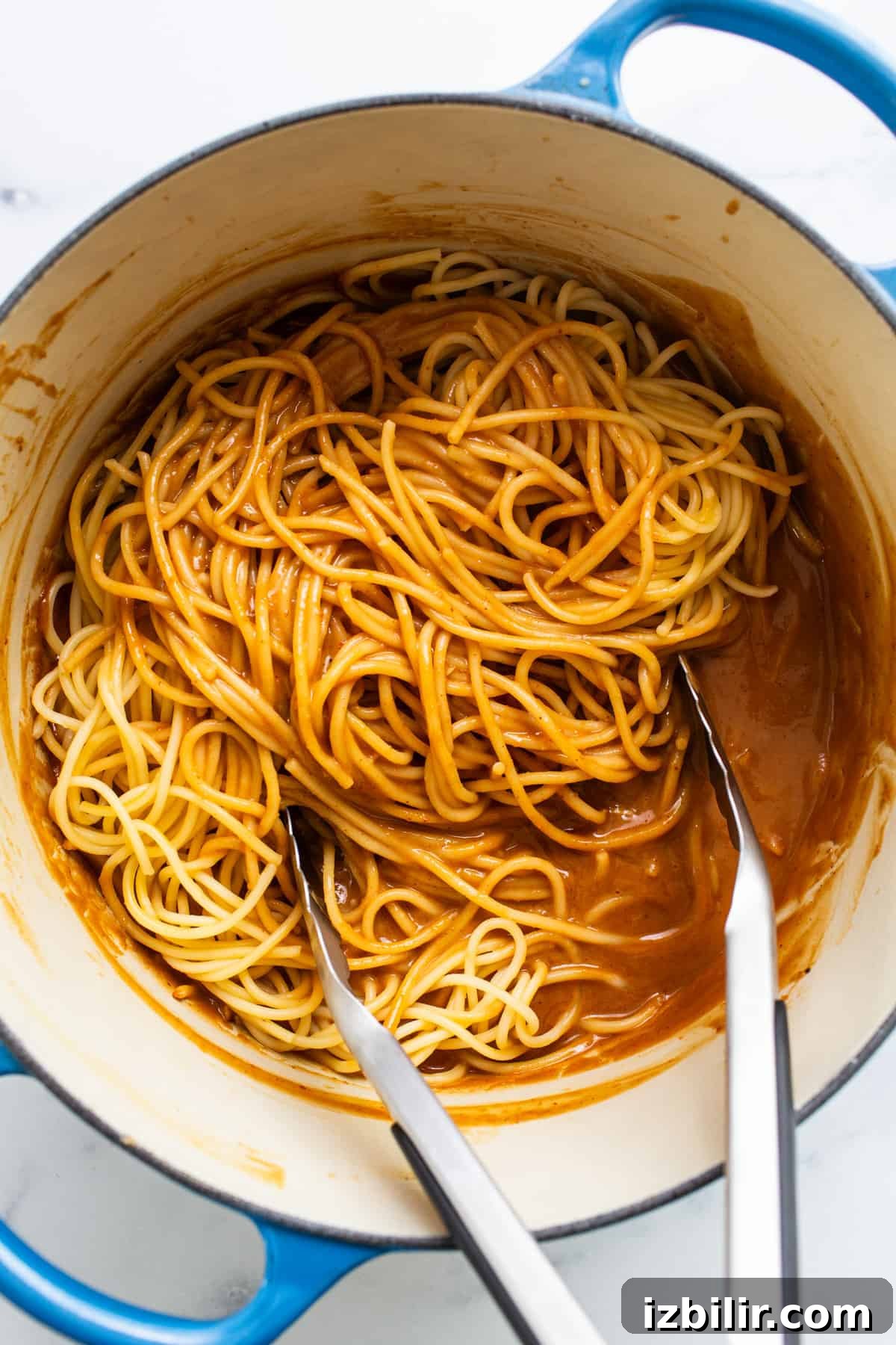 20-Minute Thai Peanut Noodles with Creamy Sauce 4 Spaghetti in a blue pot with two forks.