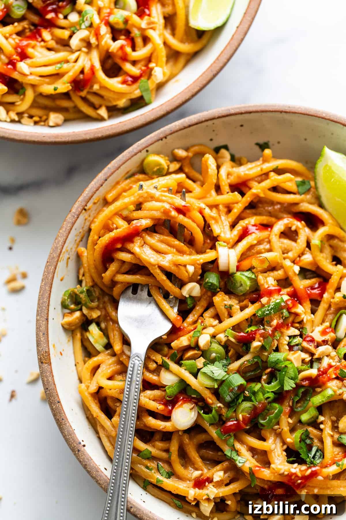 20-Minute Thai Peanut Noodles with Creamy Sauce 5 Two bowls of noodles with peanut sauce and lime.