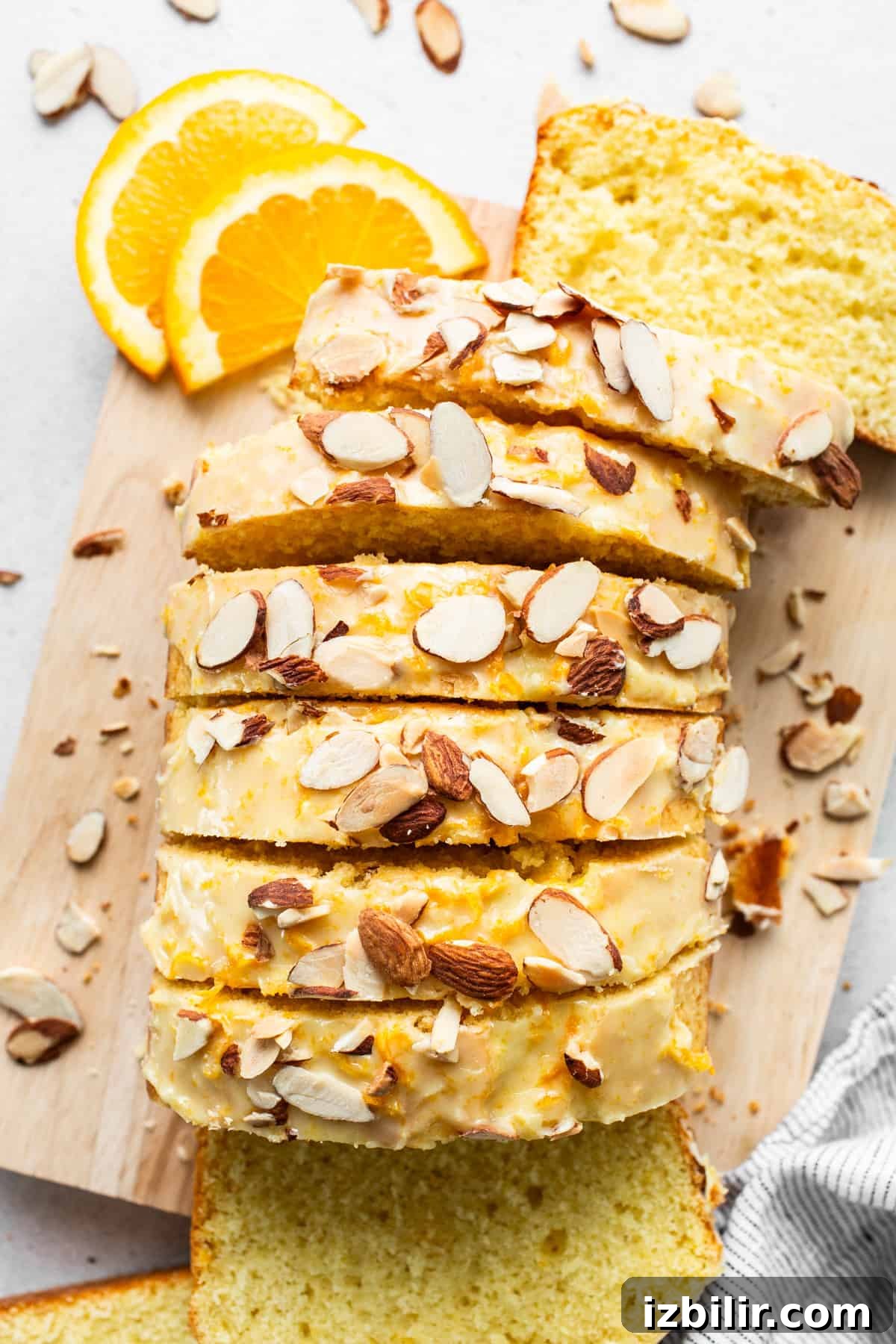 Zesty Orange Cake Recipe with Citrus Glaze 2 A slice of bread with almonds on a cutting board.