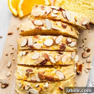Zesty Orange Cake Recipe with Citrus Glaze 12 A slice of bread with almonds on a cutting board.