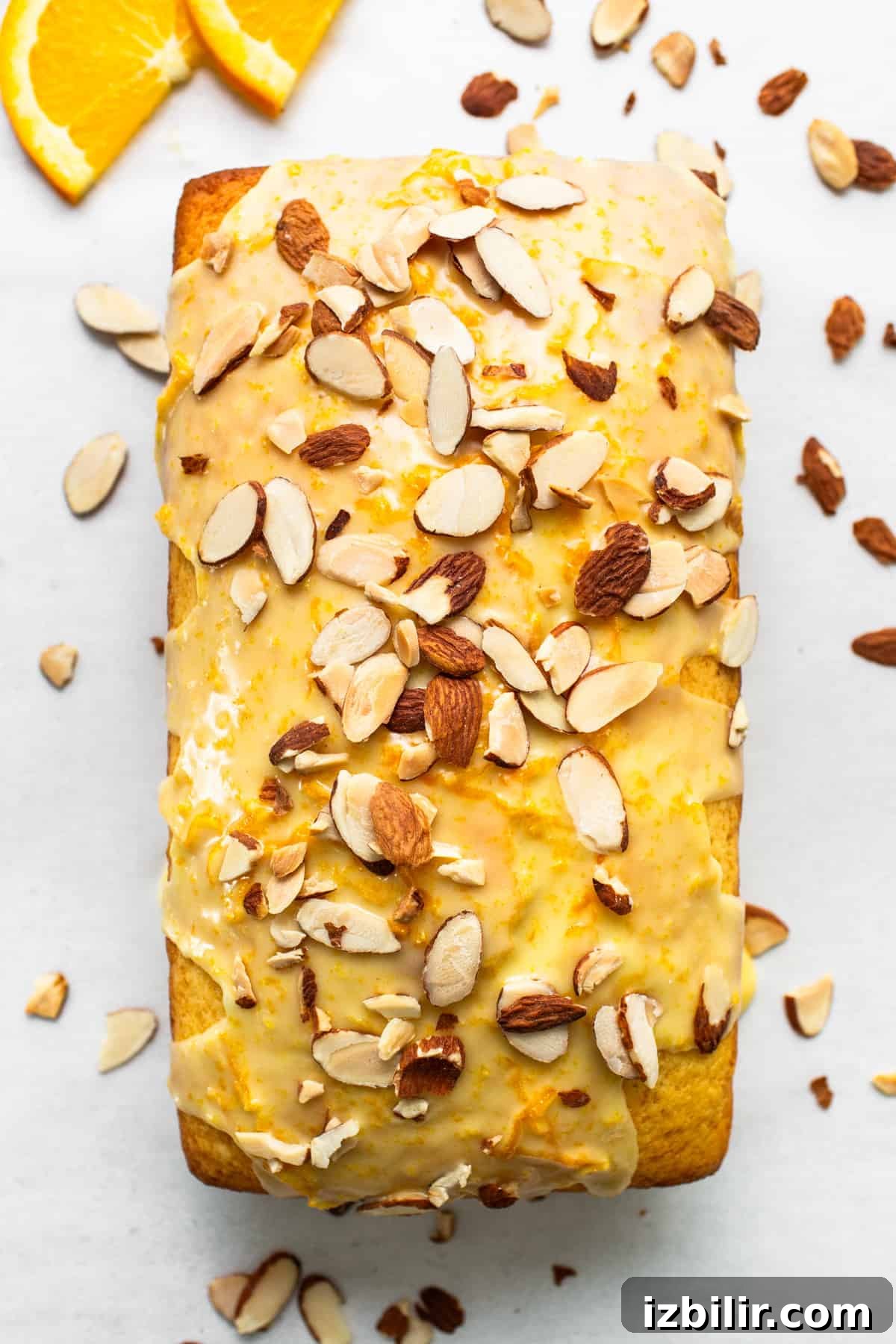 Zesty Orange Cake Recipe with Citrus Glaze 4 A loaf of orange bread with almonds and orange slices.