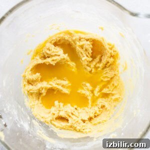 Zesty Orange Cake Recipe with Citrus Glaze 9 A glass bowl with a yellow batter in it.
