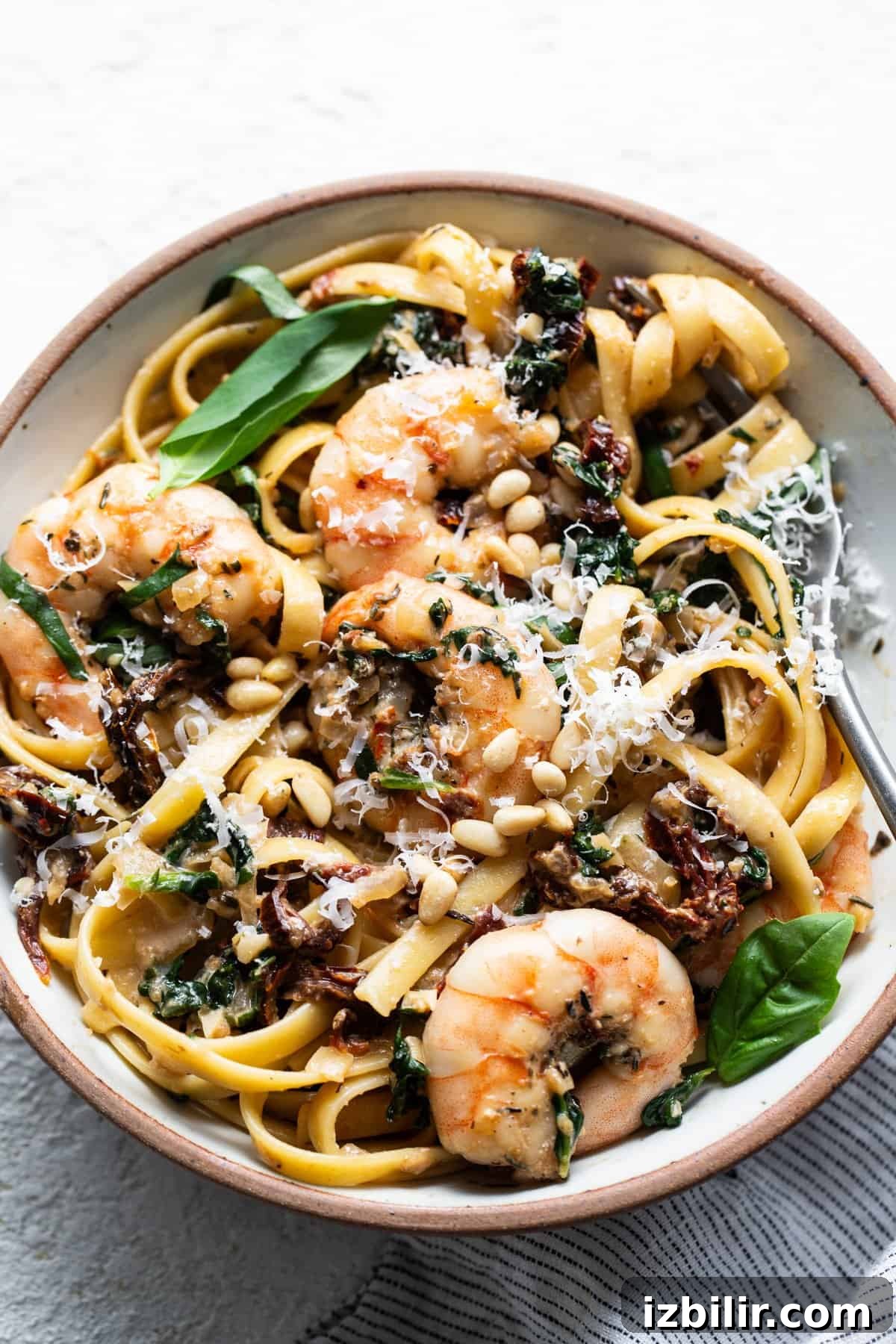 Creamy Tuscan Shrimp Linguine Recipe 2 A bowl of pasta with shrimp, mushrooms and spinach.