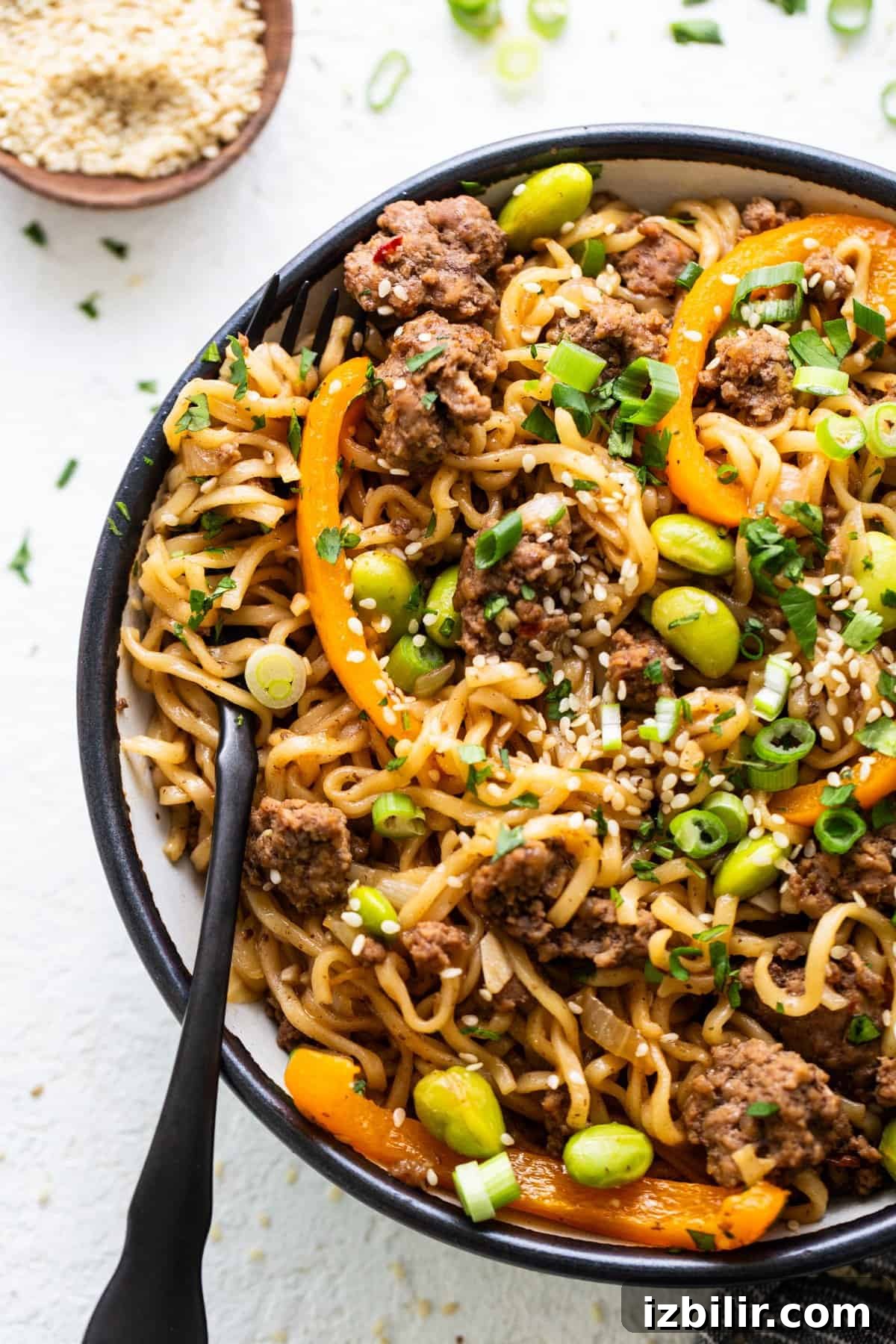 A bowl of noodles with meat and vegetables.