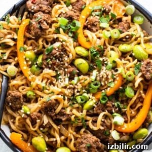 A bowl of noodles with meat and vegetables.