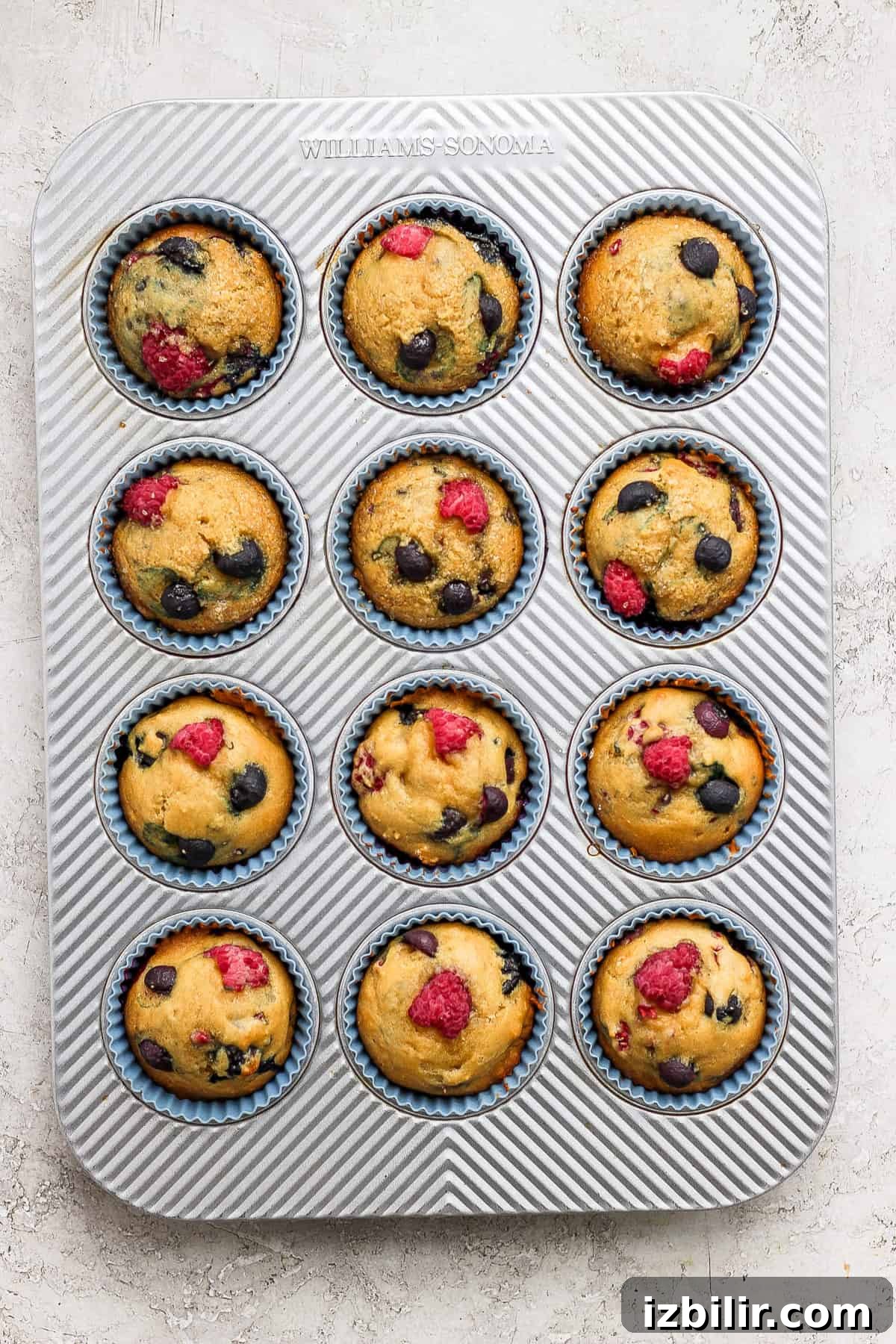 Greek Yogurt Berry Muffins with Mixed Berries 4 Muffins in a muffin tin with raspberries and blueberries.