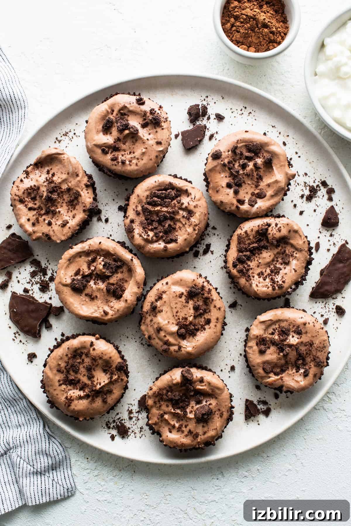 Thin Mint Chocolate Protein Mousse Cups 2 Chocolate cupcakes with chocolate frosting on a plate.