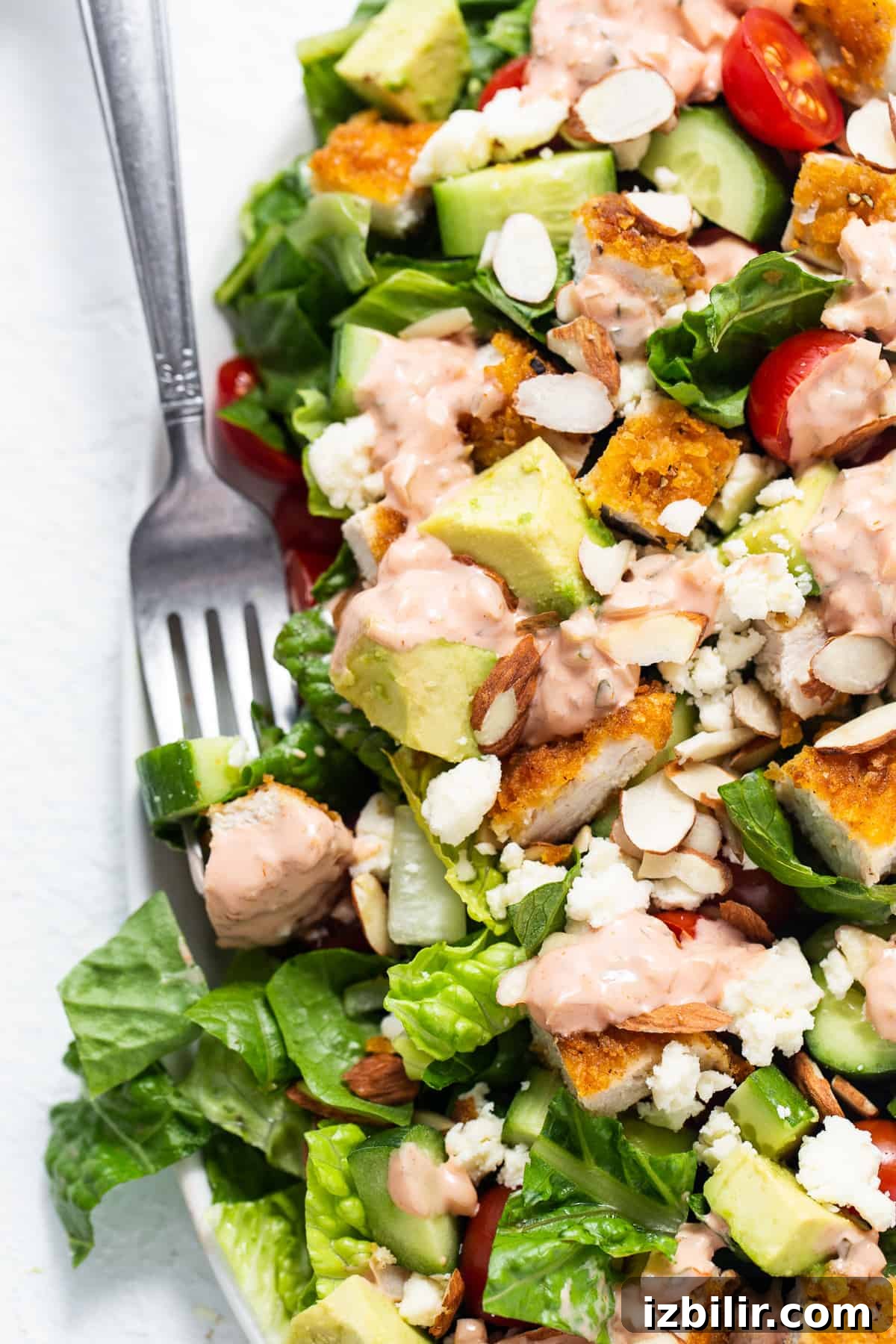 Classic Homemade Thousand Island Dressing Recipe 2 A salad with chicken, tomatoes, and avocado on a plate.