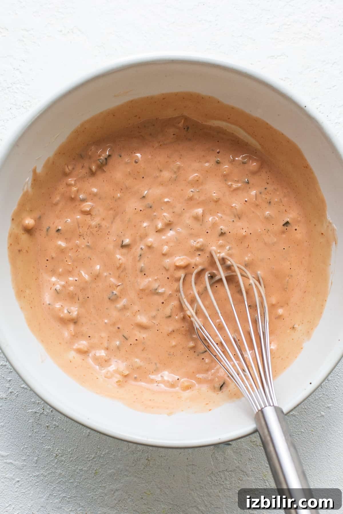Classic Homemade Thousand Island Dressing Recipe 4 A bowl of sauce with a whisk in it.