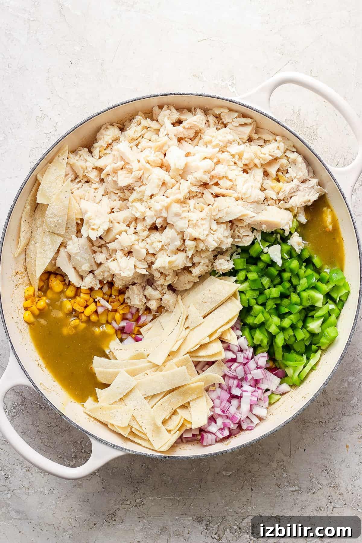 Mexican chicken enchiladas in a pan with corn and peas.