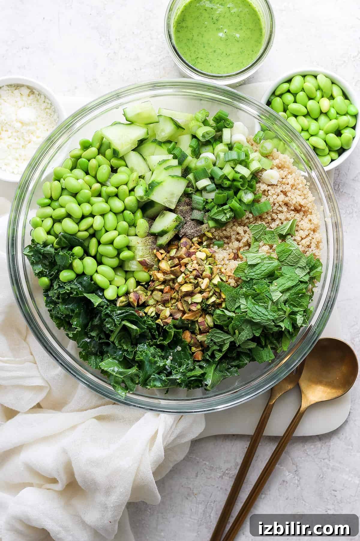Creamy Green Goddess Quinoa Salad with Avocado and Herb Dressing 2 Bowl of Green Goddess Quinoa Salad with kale, cucumbers, peas, pistachios and a jar of green dressing