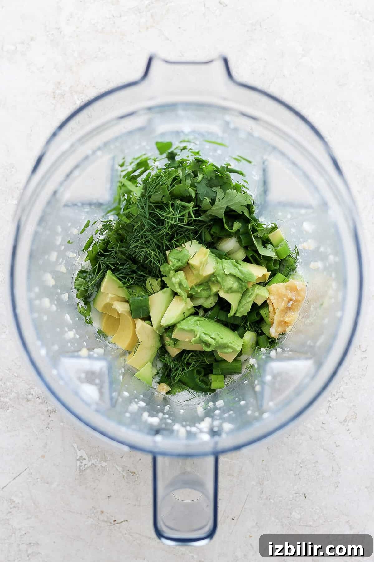 Creamy Green Goddess Quinoa Salad with Avocado and Herb Dressing 3 Blender filled with herbs, avocado and yogurt ready to blend into dressing