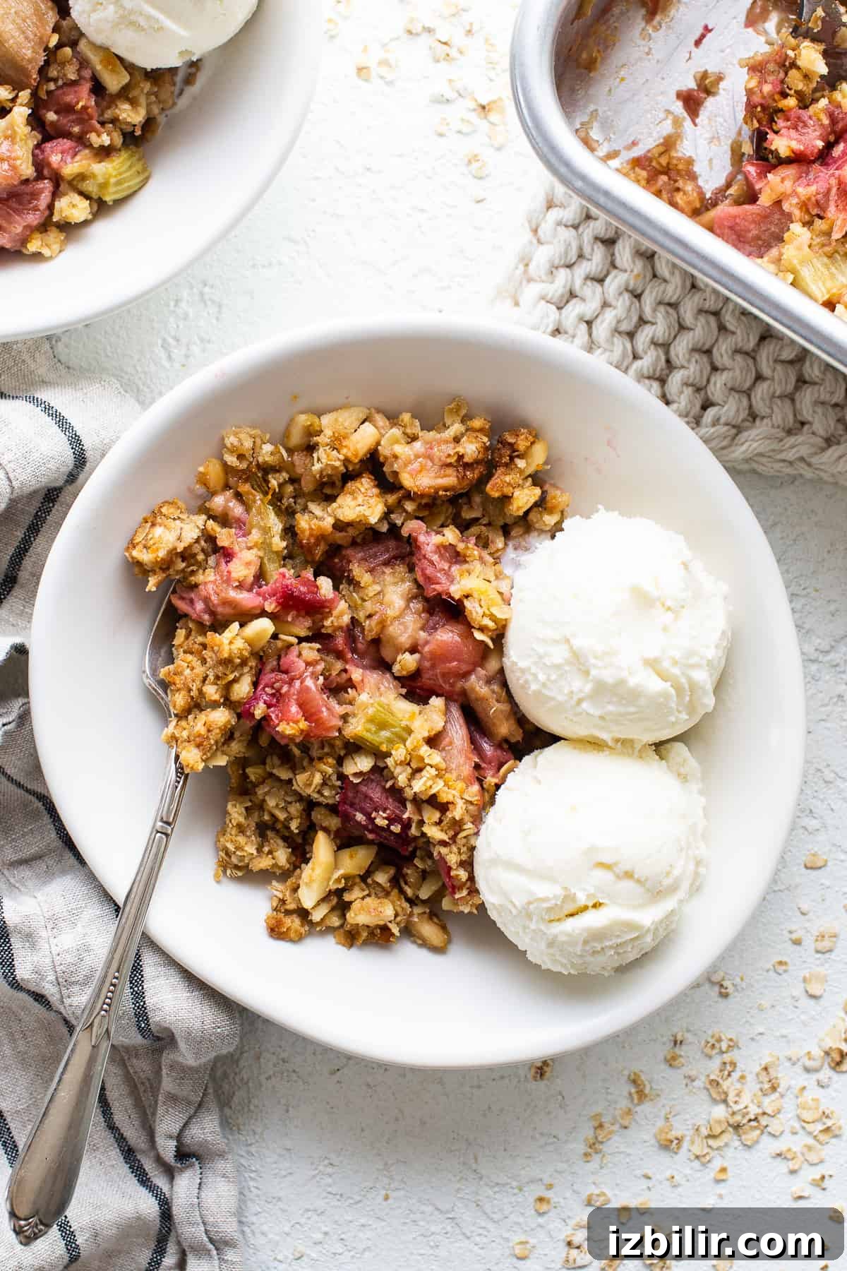 Honey Rhubarb Crisp Recipe with Brown Butter Oat Topping 2 A bowl of rhubarb crisp served with ice cream and berries