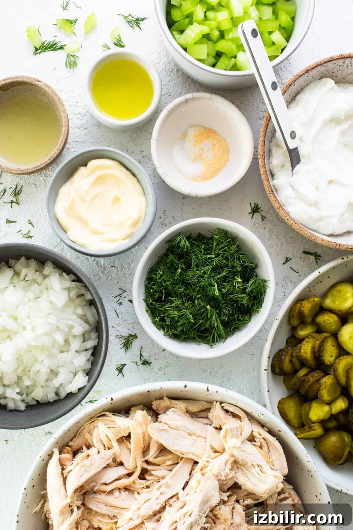 Tangy Dill Pickle Chicken Salad Recipe 3 Various ingredients prepared for cooking, including chopped vegetables, shredded chicken, and condiments.