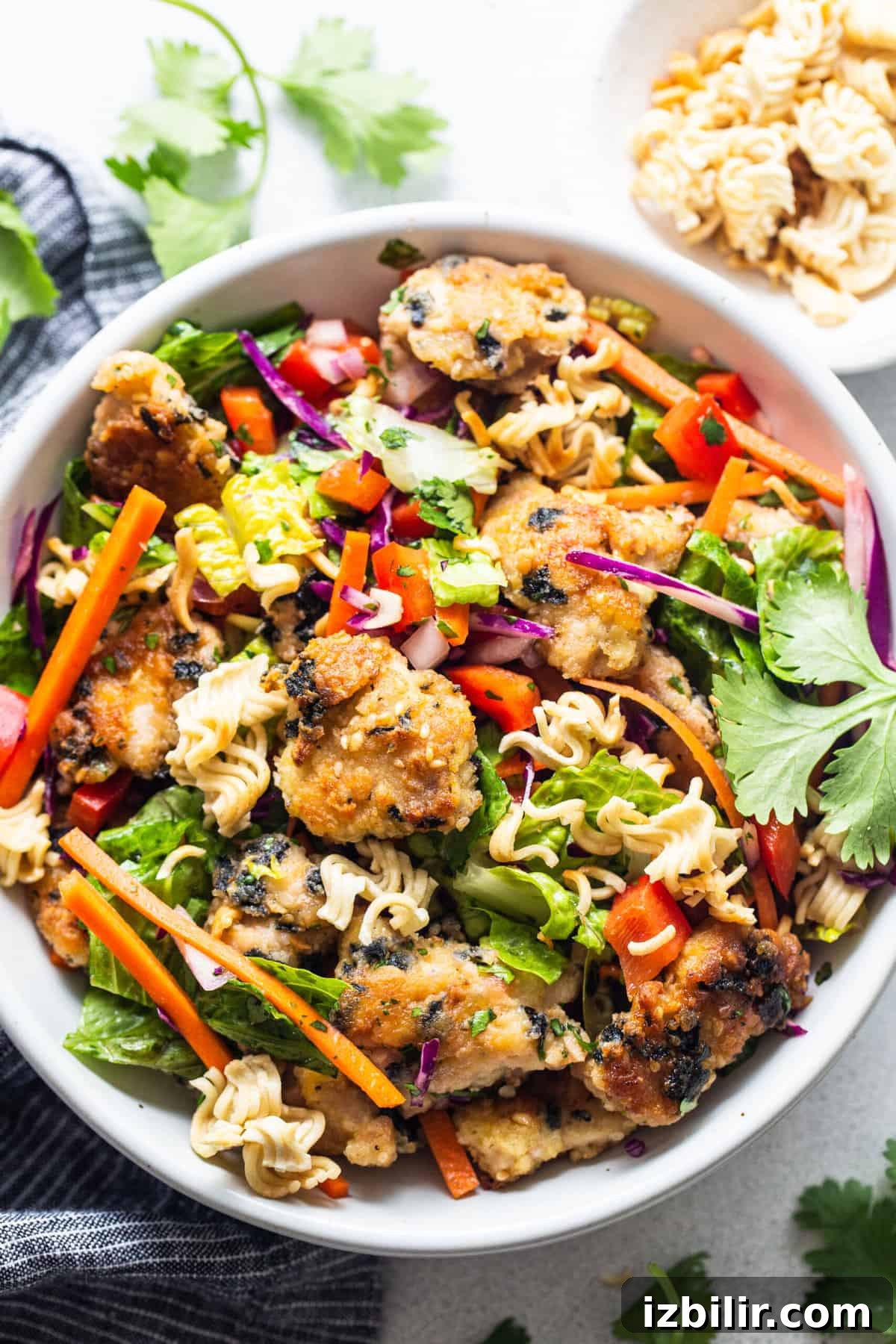 Ramen noodle salad with chicken in a bowl.
