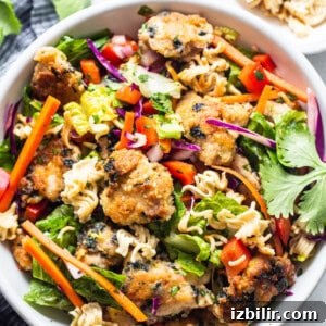 Asian chicken noodle salad in a white bowl.