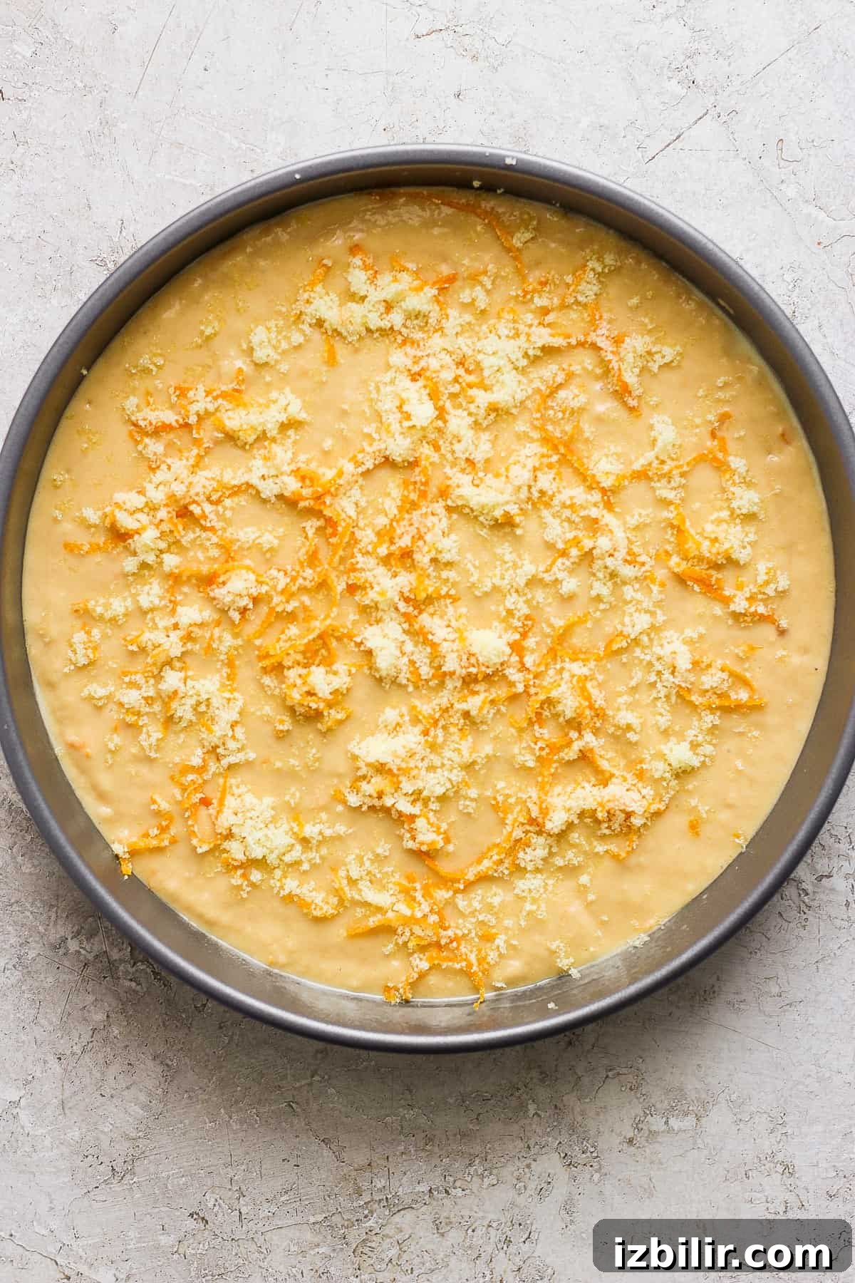 Unbaked cake batter in a round pan ready for the oven.