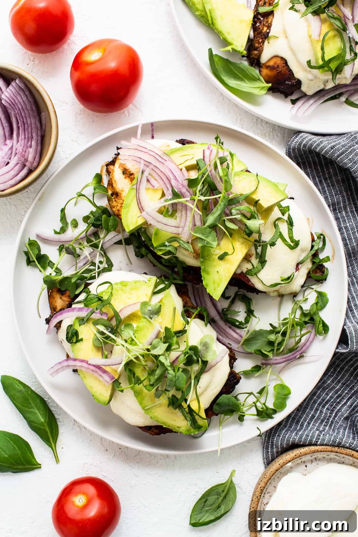 Two plates with avocado, tomatoes and onions on them.