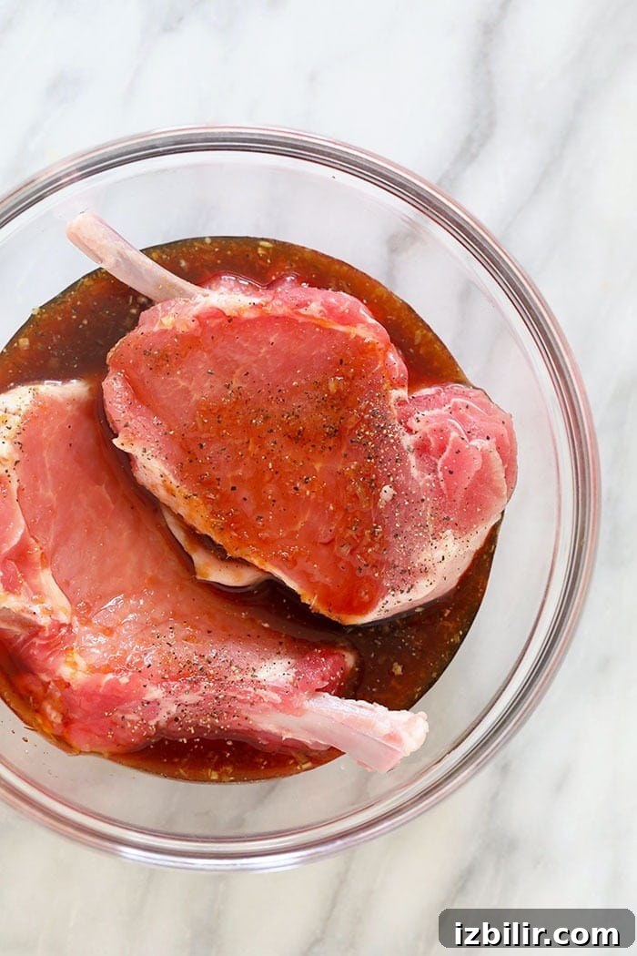 pork chops in marinade in glass bowl