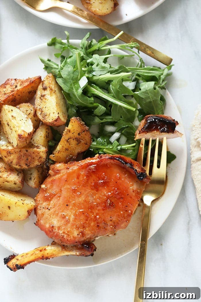 bone in pork chops with roasted potatoes on plate
