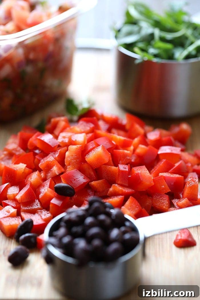 diced red peppers and measuring cup full of black beans
