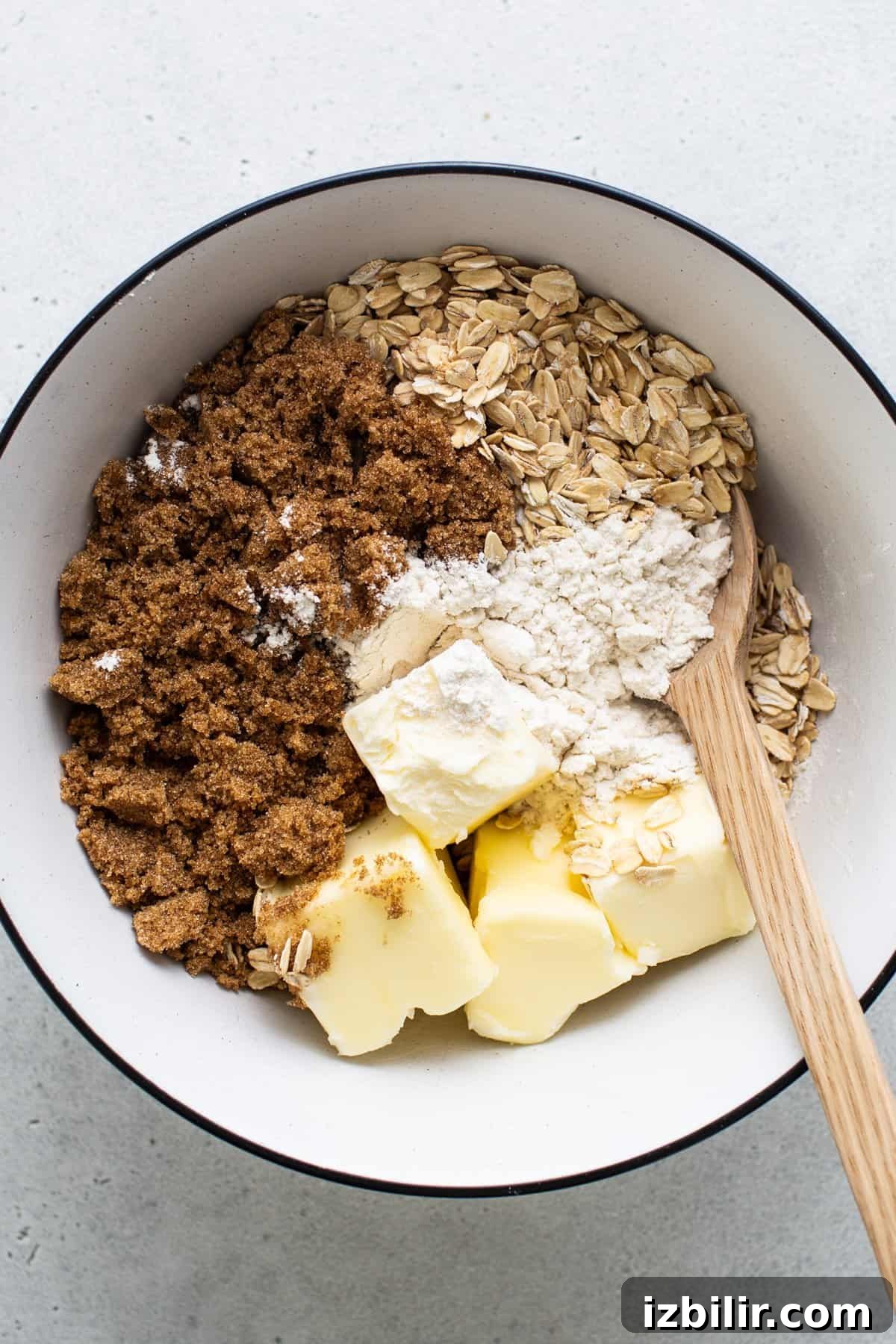 Sheet Pan Blueberry Crisp Recipe 3 Ingredients for baking in a bowl with a wooden spoon.