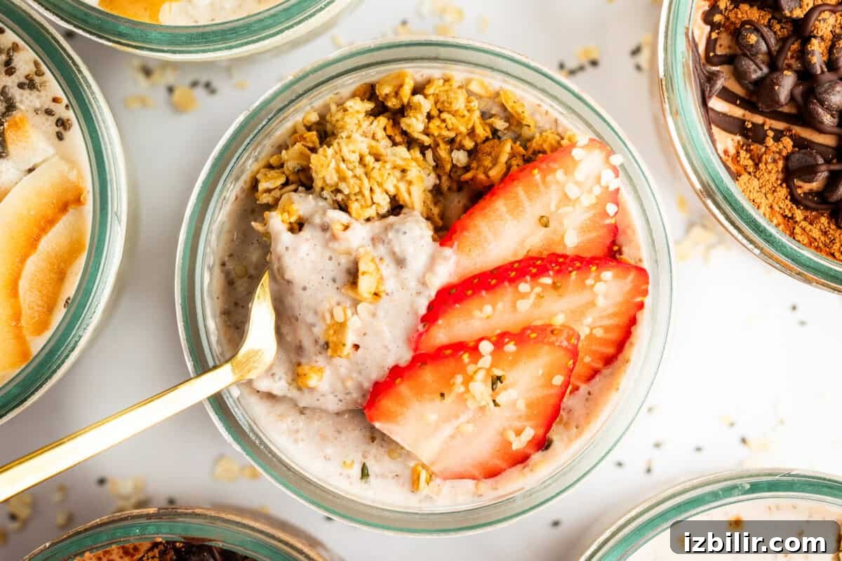 A bowl of oatmeal topped with sliced strawberries, granola, and a gold spoon placed in it.