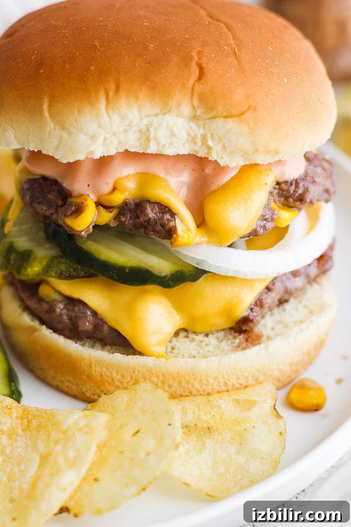 Loaded Sweet Corn Smash Burger Recipe 4 Cheeseburger with lettuce, pickles, and sauce served with potato chips.