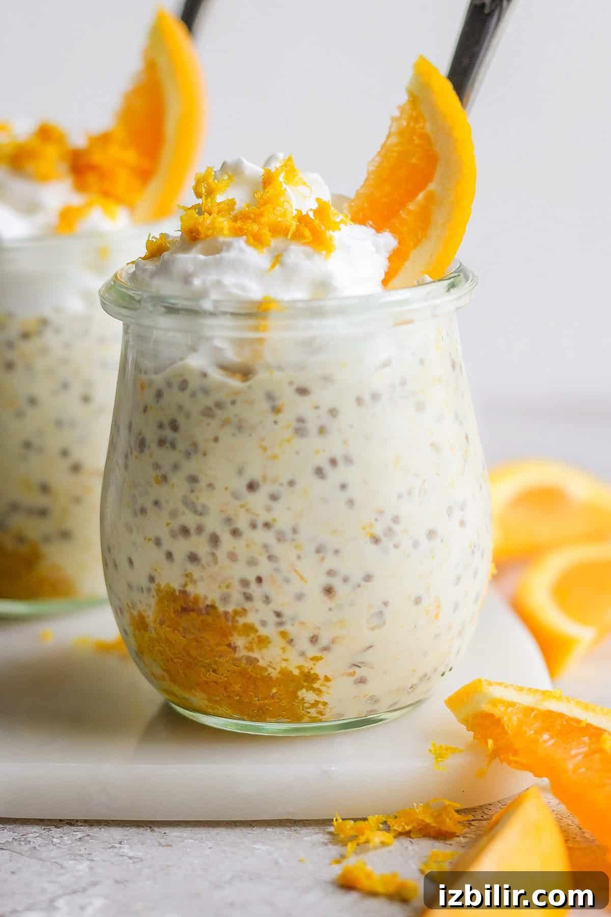 Orange Creamsicle Overnight Oats Recipe 2 Glass jar filled with creamy orange overnight oats topped with orange zest and an orange slice