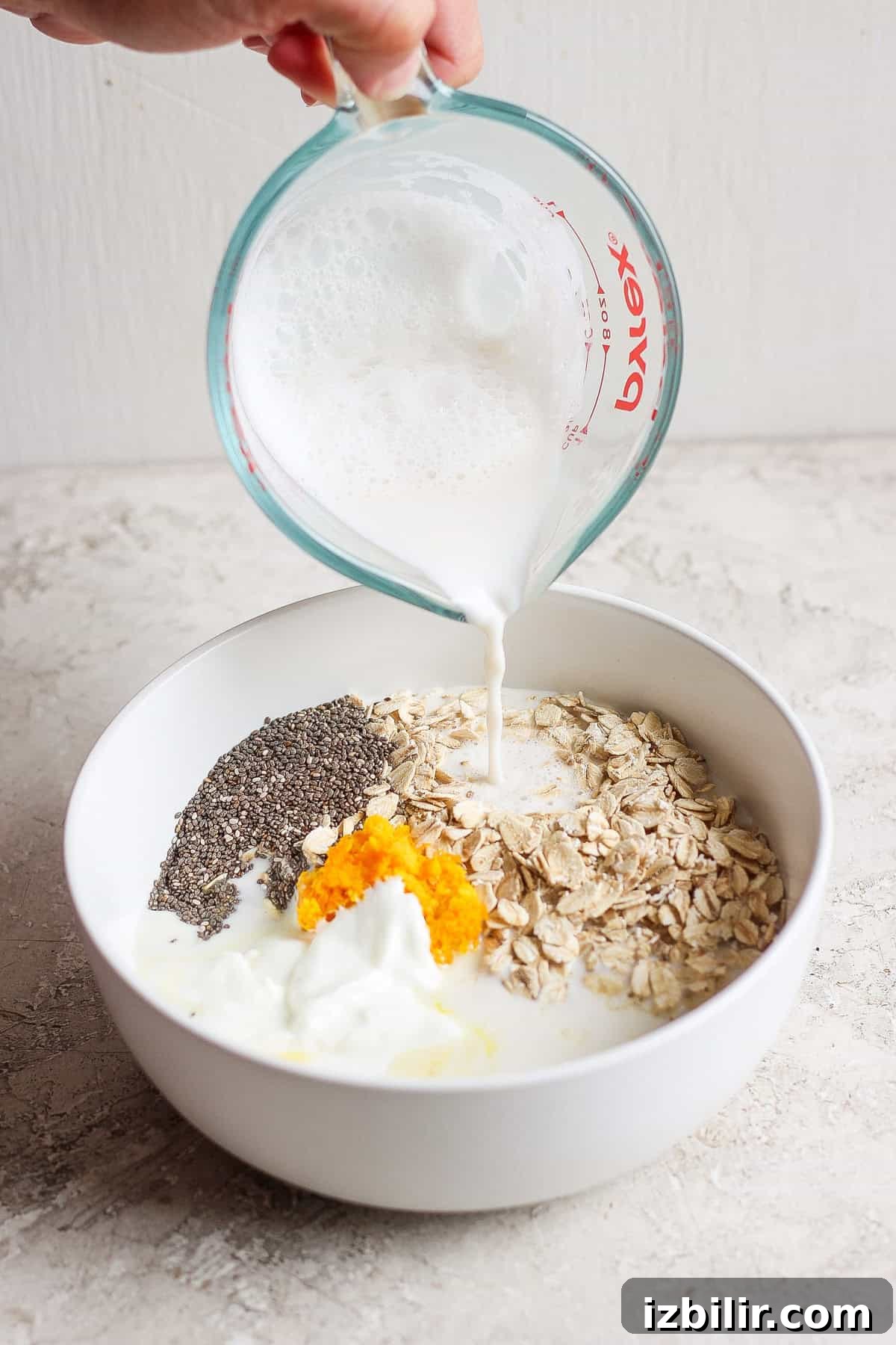 Orange Creamsicle Overnight Oats Recipe 4 Pouring milk into a bowl with oats and orange zest