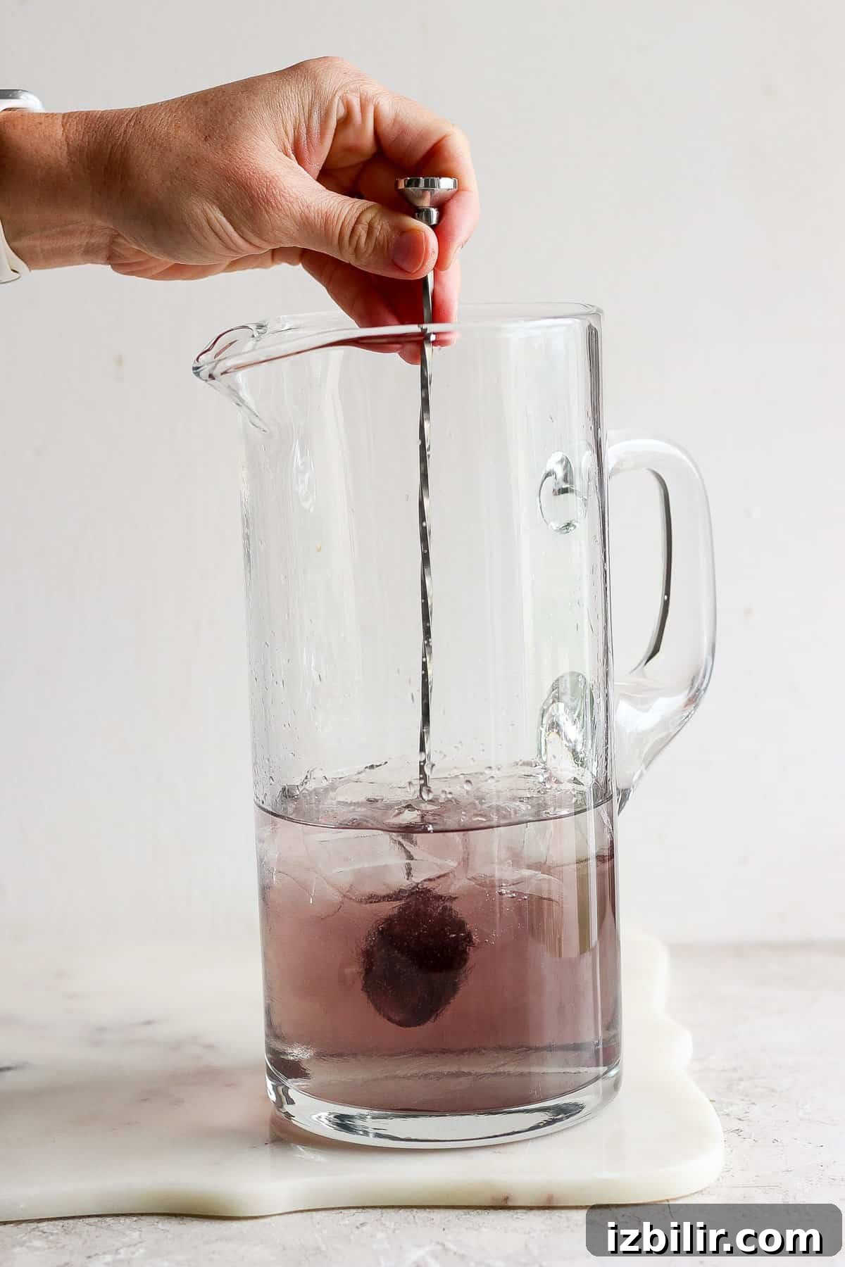 Sparkling Unicorn Gin Cocktail Recipe 3 Stirring purple tea in a pitcher