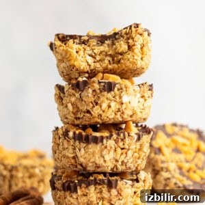 Pumpkin Spice Oatmeal Cups Recipe 7 A stack of granola clusters with chocolate coating and peanut toppings.