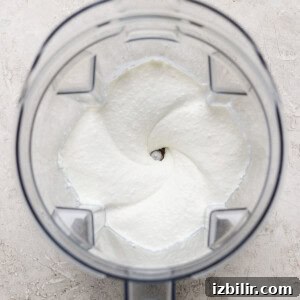 A blender jar with a smooth white mixture ready to be used in a recipe.