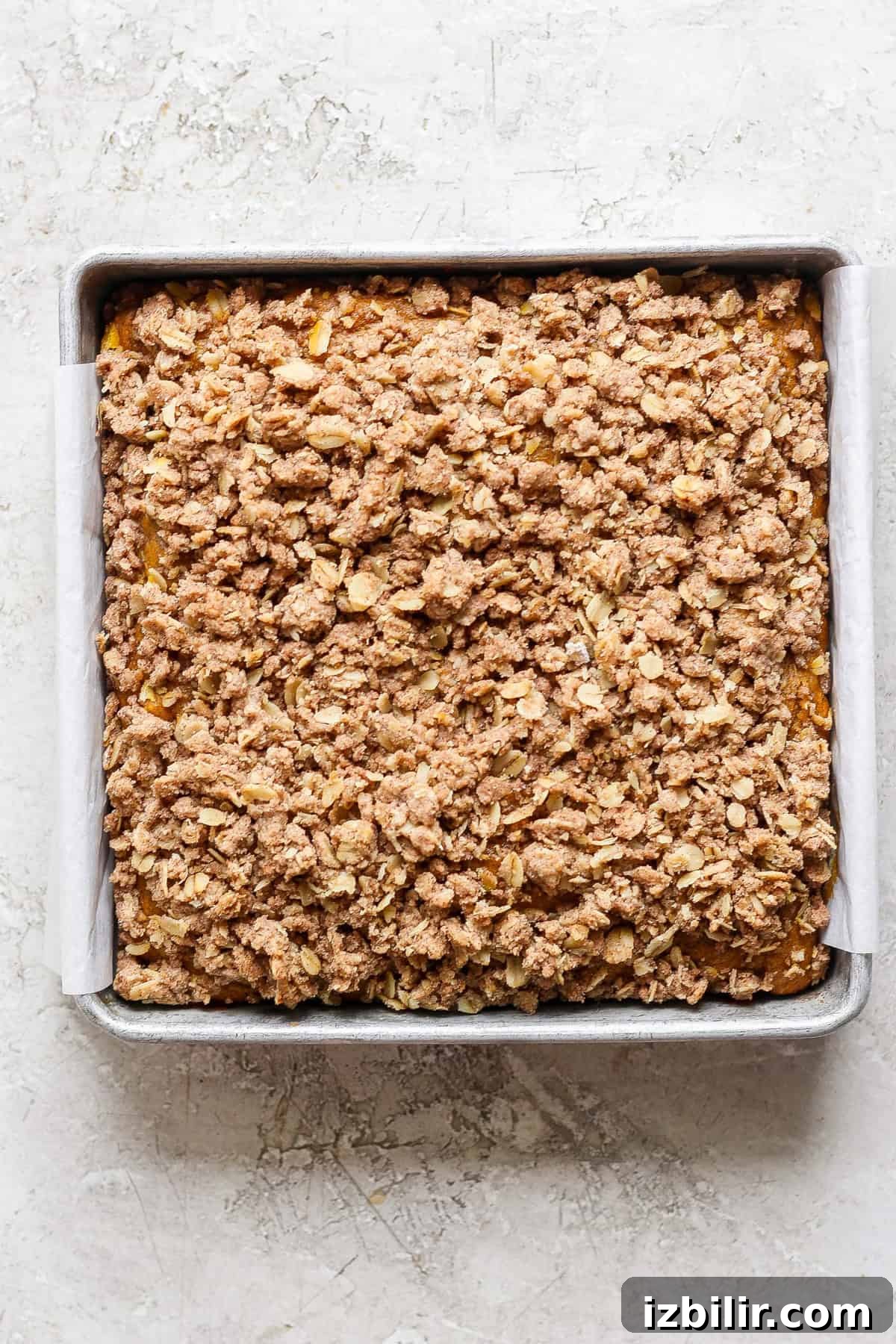 Pumpkin Coffee Cake with Cinnamon Streusel 5 A square baking pan filled with baked oatmeal fruit crumble topped with a crispy oat and cinnamon streusel.