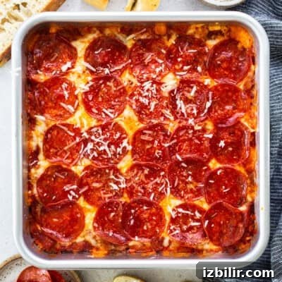 Square pan of pepperoni pizza with a golden crust, melted cheese, and sliced pepperoni.