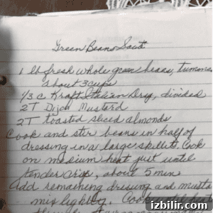 Handwritten recipe on paper with fresh ingredients nearby.
