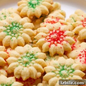A plate of star-shaped cookies with red and green sprinkles.