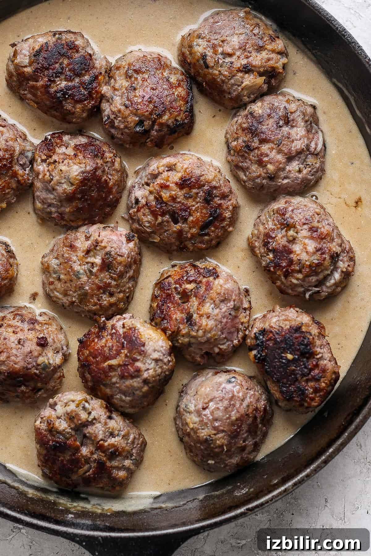 Minnesota-Style Swedish Meatballs with Creamy Gravy 4 A skillet containing several browned meatballs in a creamy gravy.