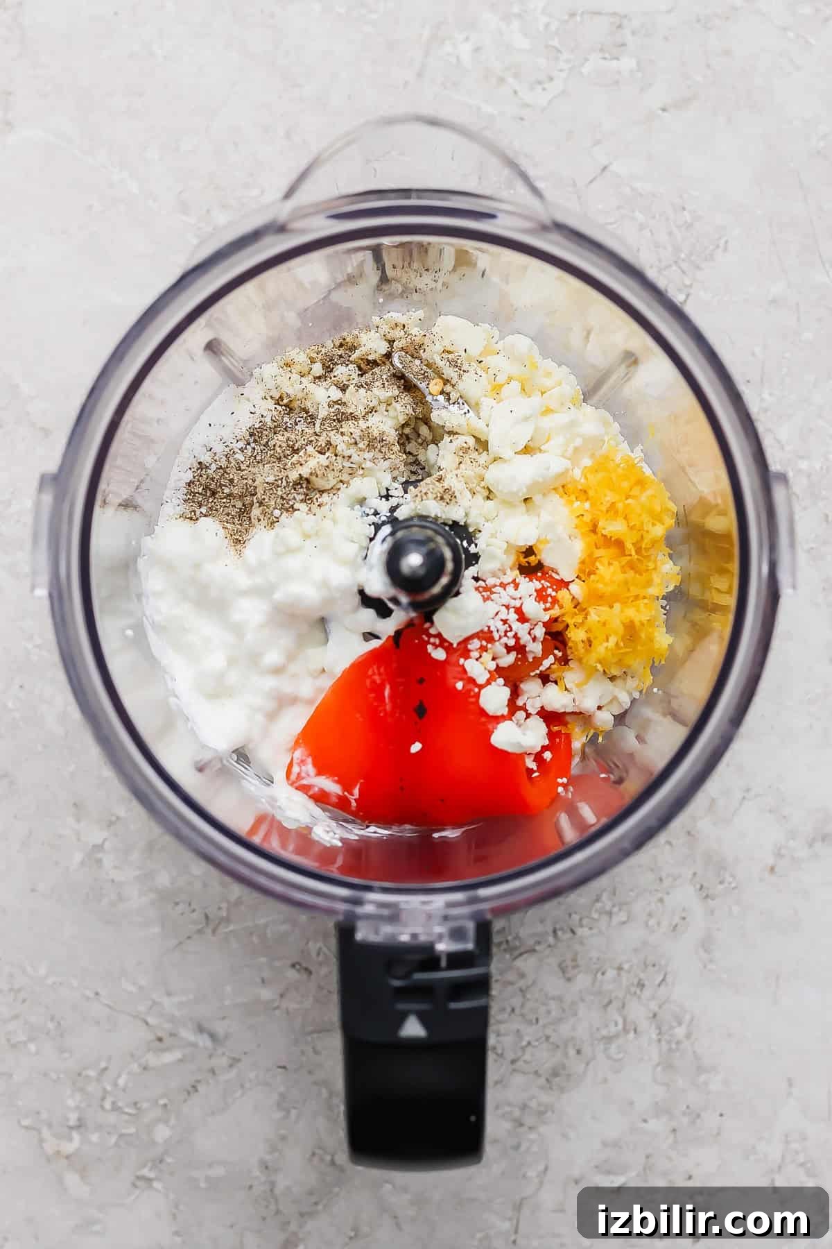 Roasted Red Pepper Pasta Salad with Cottage Cheese 3 Ingredients including pepper, feta cheese, cottage cheese, lemon zest, and red peppers in a food processor, ready to be blended.