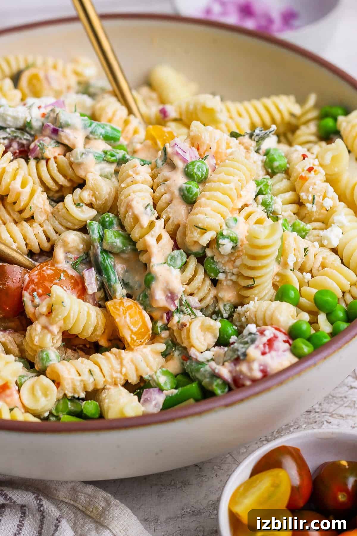 Roasted Red Pepper Pasta Salad with Cottage Cheese 6 A bowl of rotini pasta salad with peas, asparagus, cherry tomatoes, and a creamy dressing.