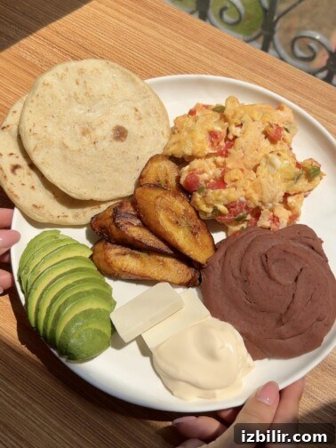 Typical Central American breakfast plate with eggs, plantains, beans and avocado