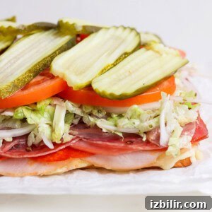 Italian Grinder Sliders Recipe: Classic Mini Italian Sandwiches 9 Assembled sliders topped with lettuce, tomato, pickles, and mayonnaise.