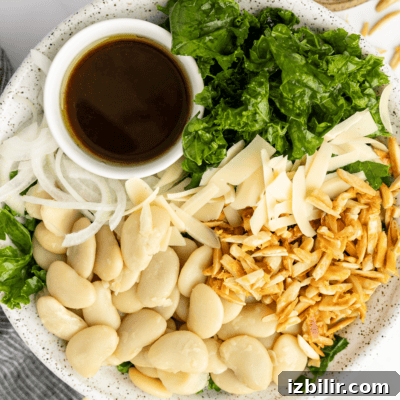 Thanksgiving Sides Worth Serving (Everything But Turkey) 12 A plate with butter beans, sliced onions, kale, shredded cheese, toasted slivered almonds, and a small cup of dark dressing.