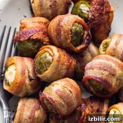 Thanksgiving Sides Worth Serving (Everything But Turkey) 21 Bacon wrapped brussels sprouts on a plate.