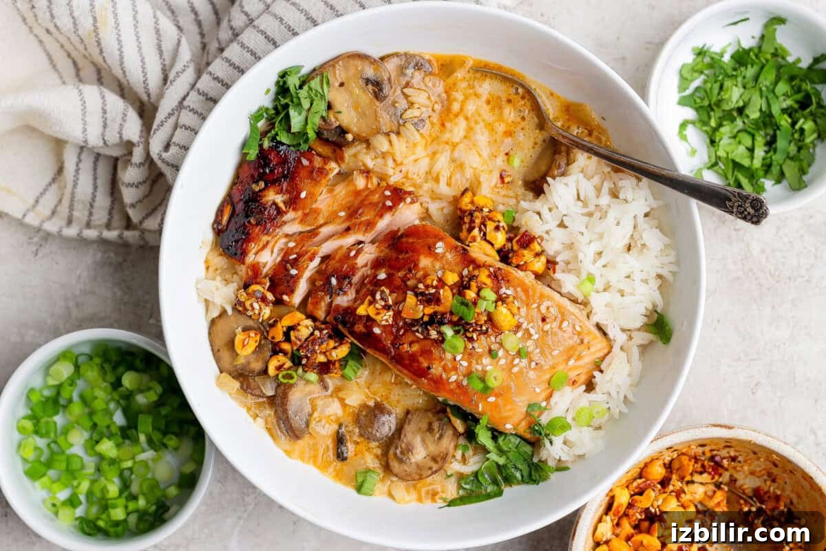 A bowl of white rice, grilled salmon with sauce, mushrooms, chopped nuts, sesame seeds, and herbs, with small bowls of sliced green onions and chopped herbs nearby.