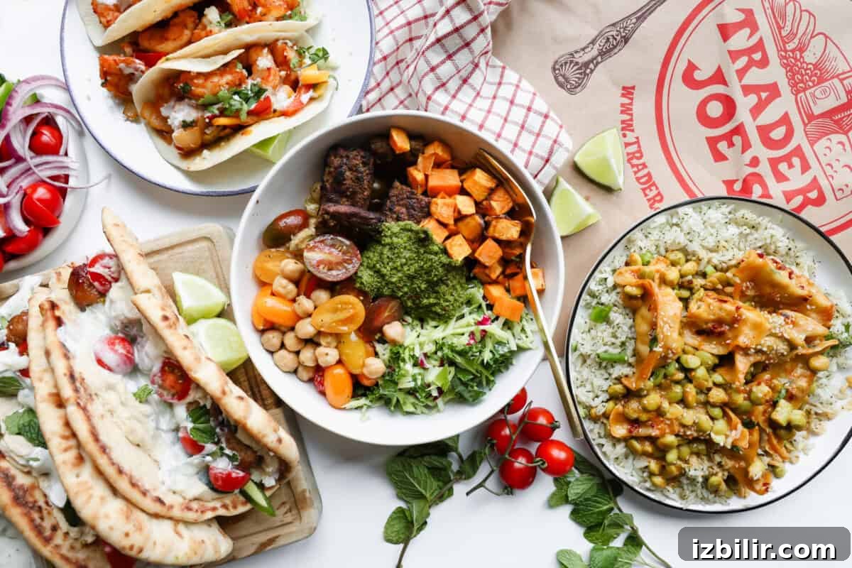 Assorted dishes with tacos, naan wraps, rice with vegetables, a grain bowl with sweet potatoes and greens, and a Trader Joe's paper bag on a white surface.