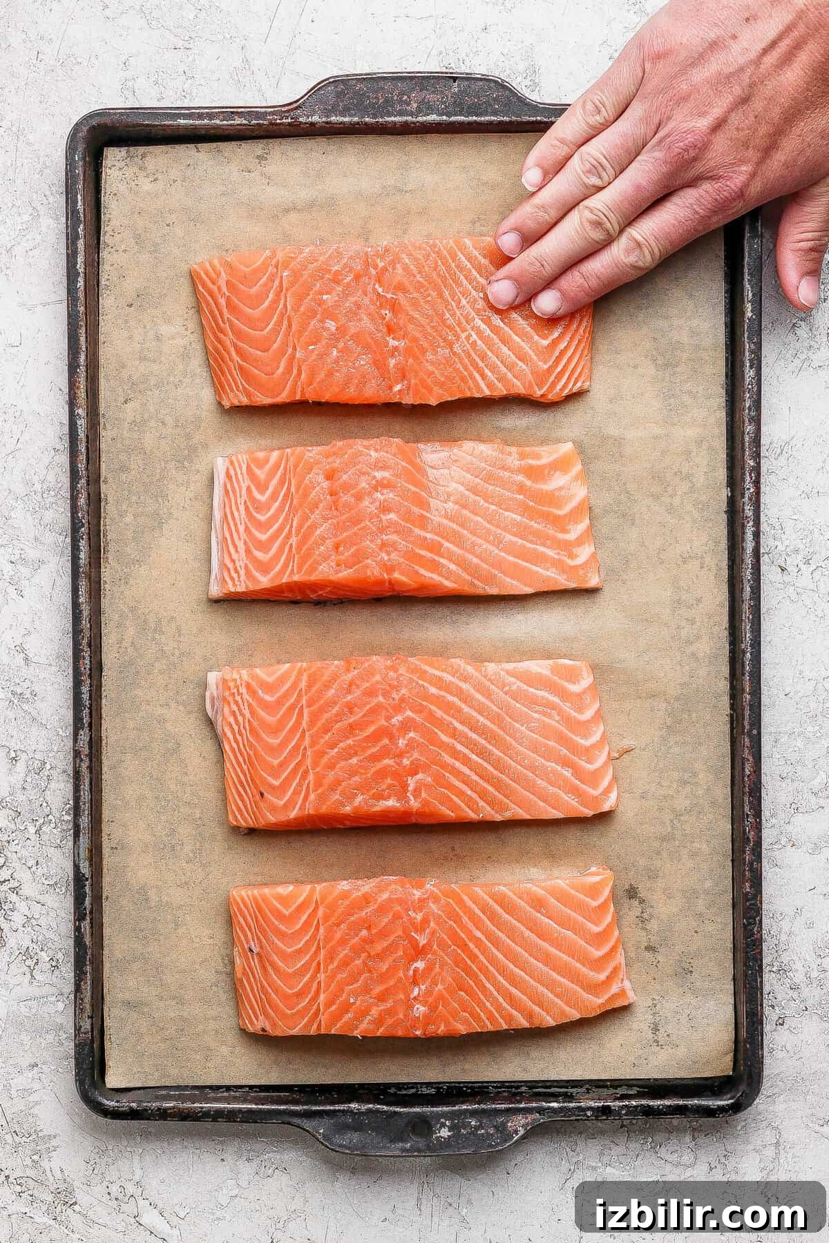 8-Minute Broiled Salmon with Simple Seasoning 5 Seasoned salmon fillets arranged on a parchment-lined baking sheet ready for the broiler.